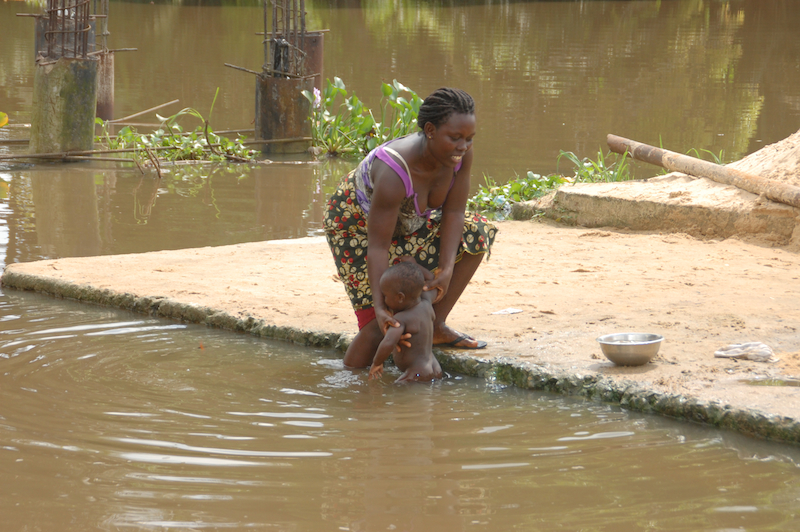 A woman bathing her baby in the water