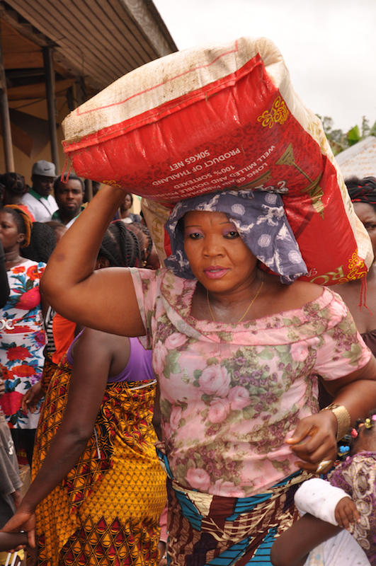 A woman taking a bag of rice to her ward to be shared amongst the families there