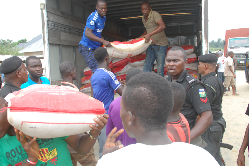 Bags of rice taken off truck to be loaded on speed boats